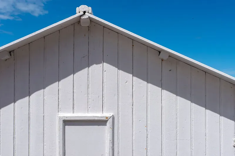 Freshly washed white weatherboard cladding against a clear blue sky